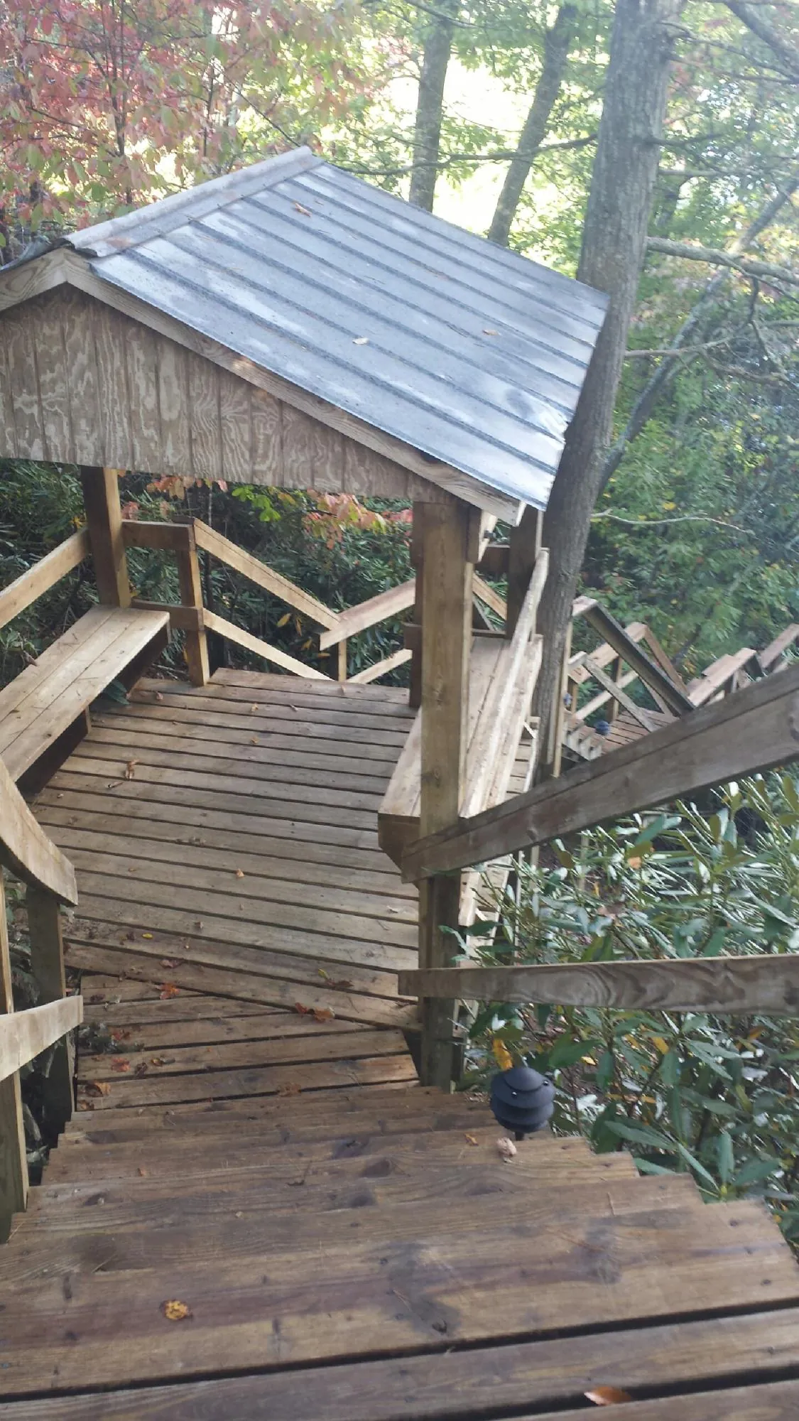 Metal roofed shelter over wooden steps on a wooded walkway — Skylight Repair & Installation work by our crew in Ewa Beach